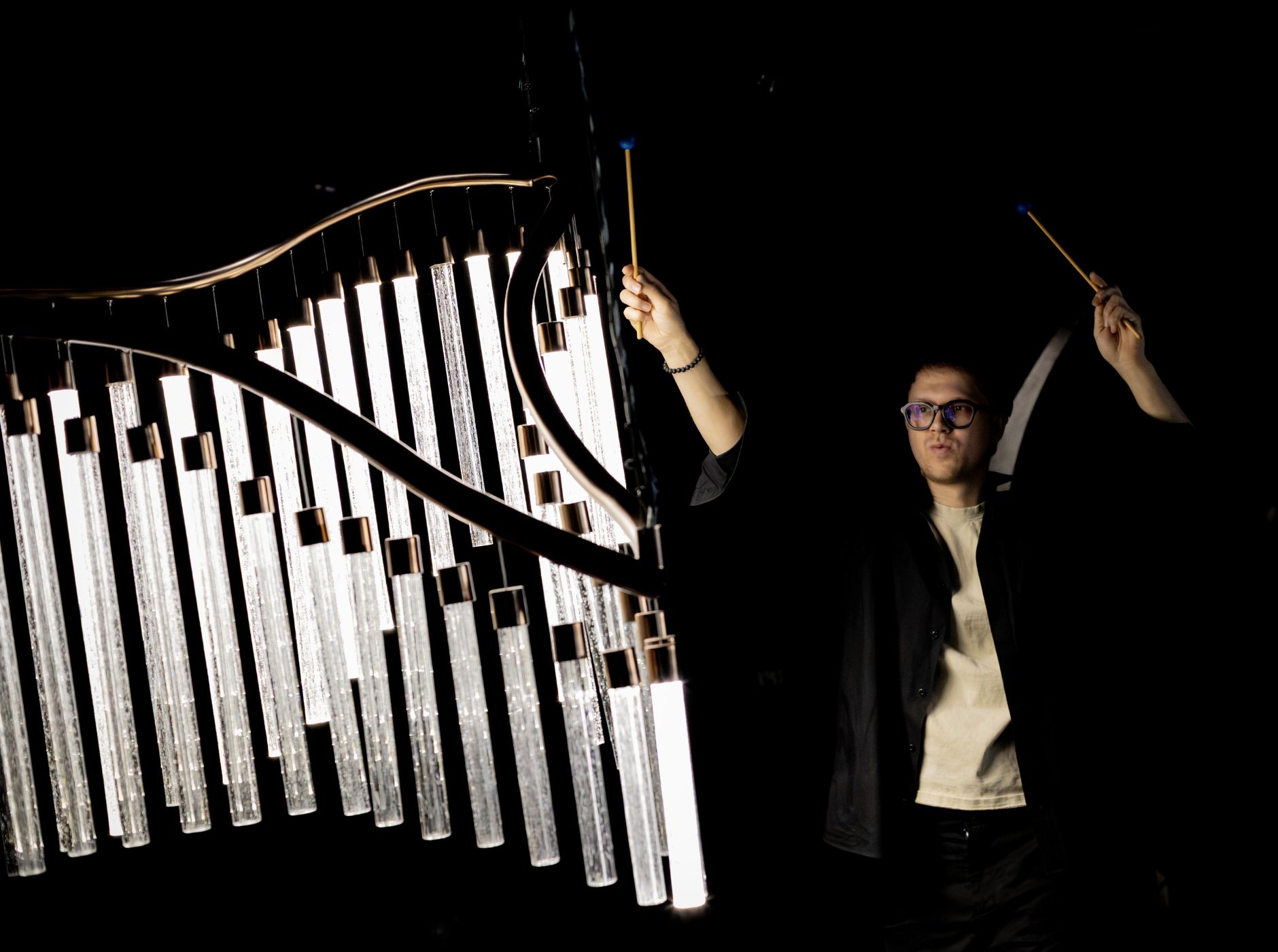 An artist interacts with a light installation during Preciosa Lighting Open Day.
