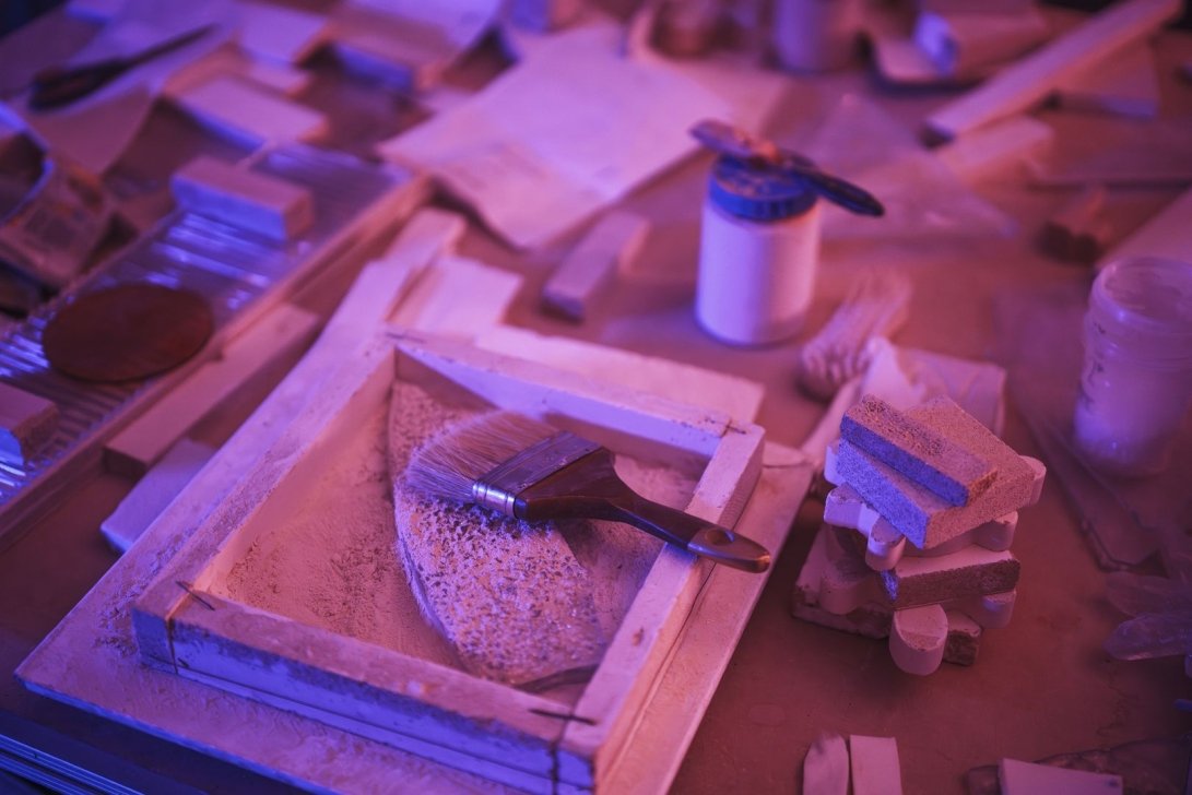 Artistic workspace with painting tools and colorful textures.