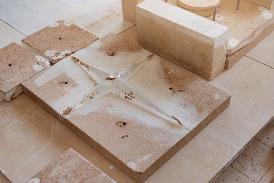 Castings and molds on a work surface with fragments and dust.