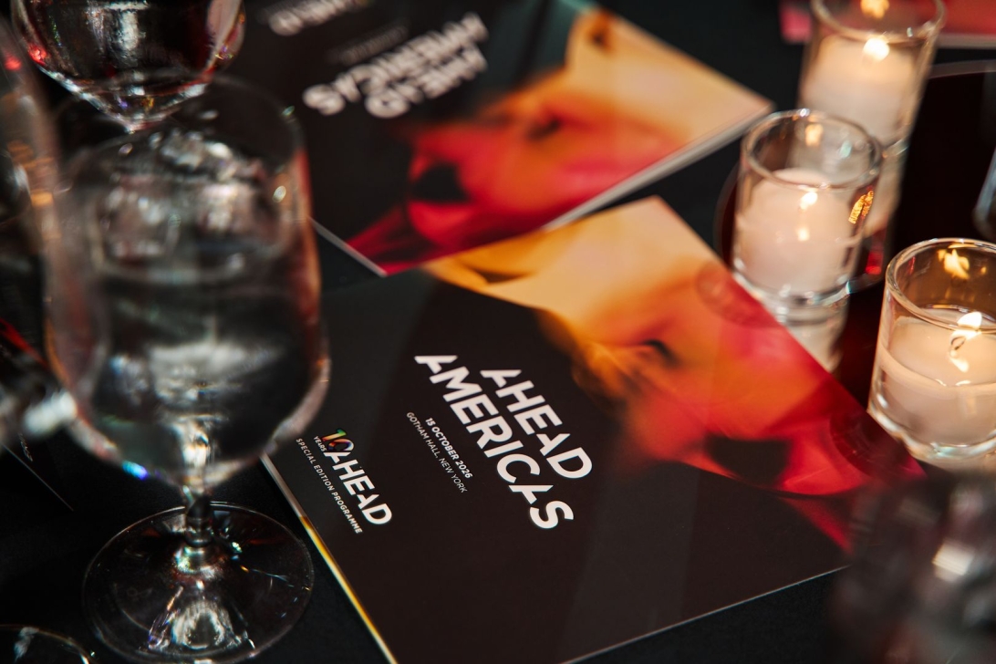 AHEAD Americas program on the table, illuminated by candles and glasses of water.