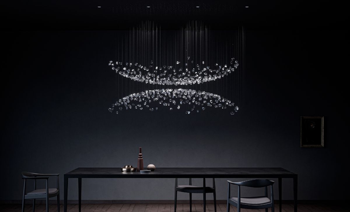 Elegant chandelier above a table in a dark interior at Downtown Design Dubai 2025.