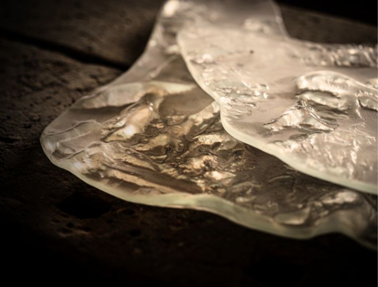 Glass plates with intricate texture on a dark background.