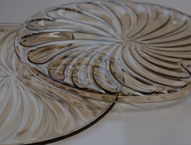 Two glass plates with a spiral pattern on a light background.