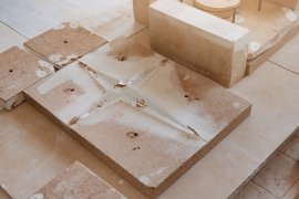 Castings and molds on a work surface with fragments and dust.