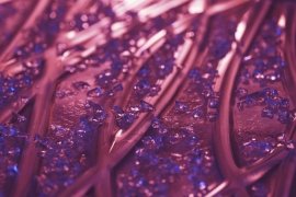 Purple and blue crystals on a smooth surface, evoking abstract art.