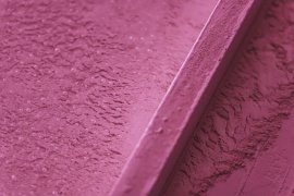 Textured pink surface with subtle details and bubbles.