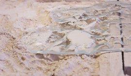 Transparent material on a sandy surface with intricate details and texture.