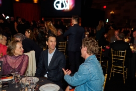 Participants at the AHEAD Americas gala engage in conversation at their table.