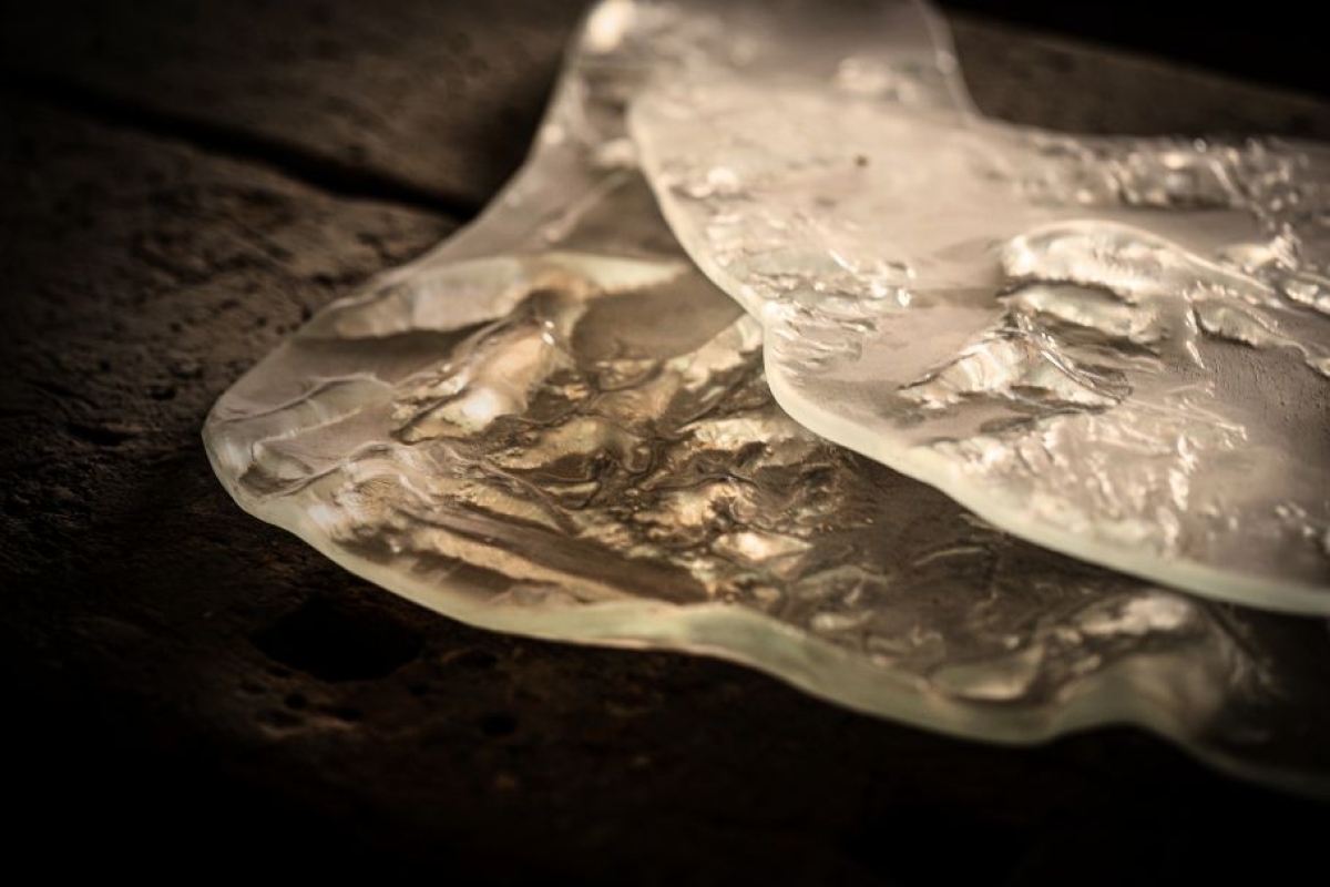 Smooth glass pieces with intricate details on a dark background.